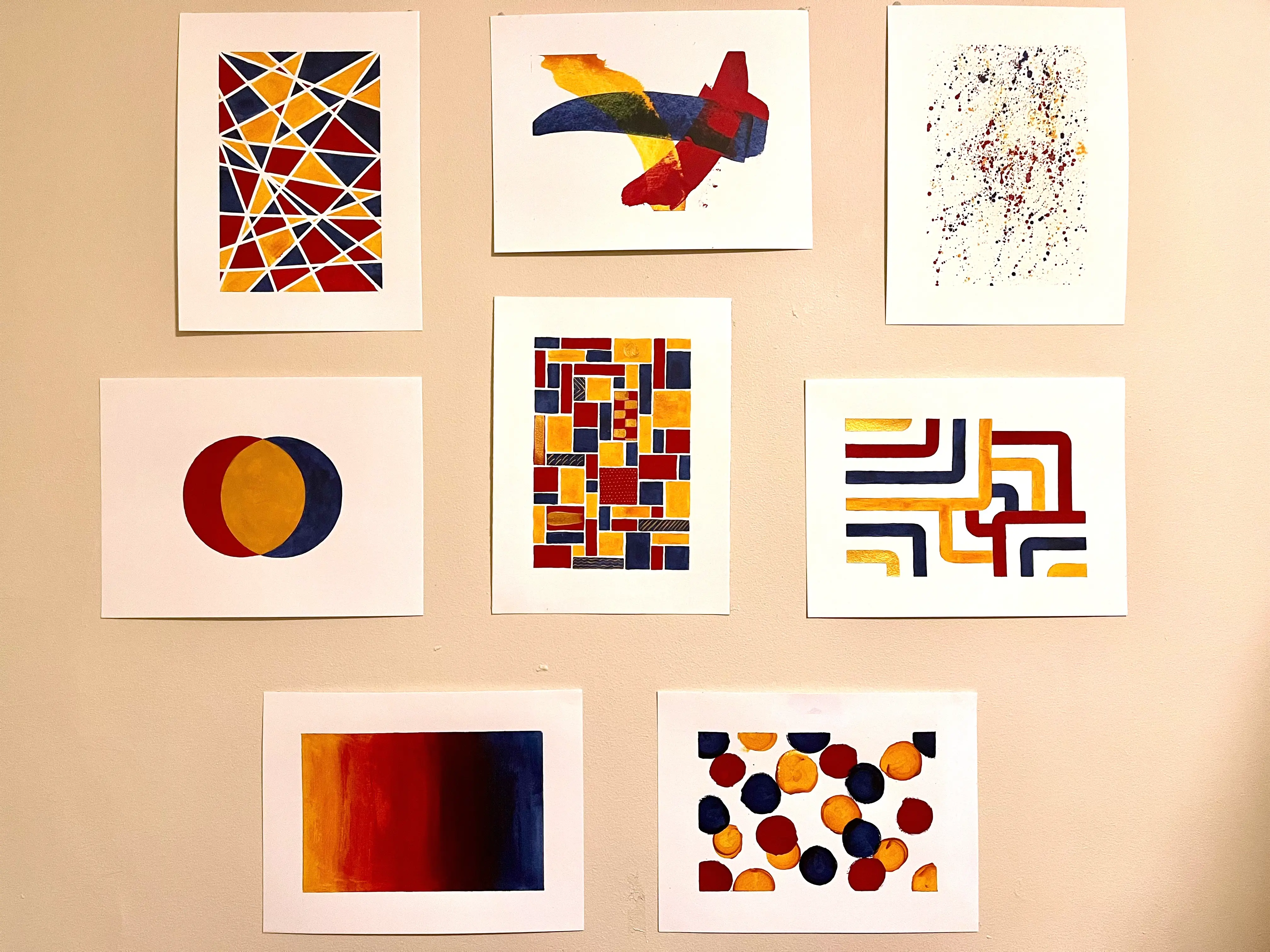 A collection of eight abstract paintings in red, yellow, and blue on white watercolor paper.